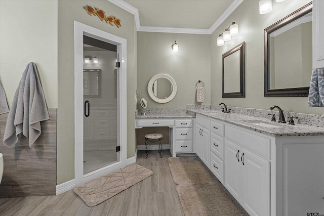 bathroom featuring an enclosed shower, vanity, and ornamental molding