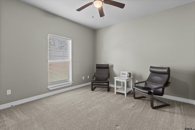 living area featuring light carpet and ceiling fan