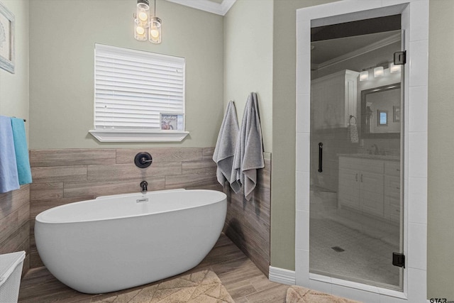 bathroom featuring plus walk in shower, ornamental molding, and sink