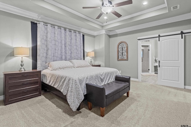 carpeted bedroom with a tray ceiling, ceiling fan, ensuite bathroom, crown molding, and a barn door