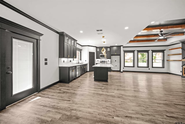 kitchen with dark hardwood / wood-style flooring, ceiling fan, sink, beamed ceiling, and a kitchen island