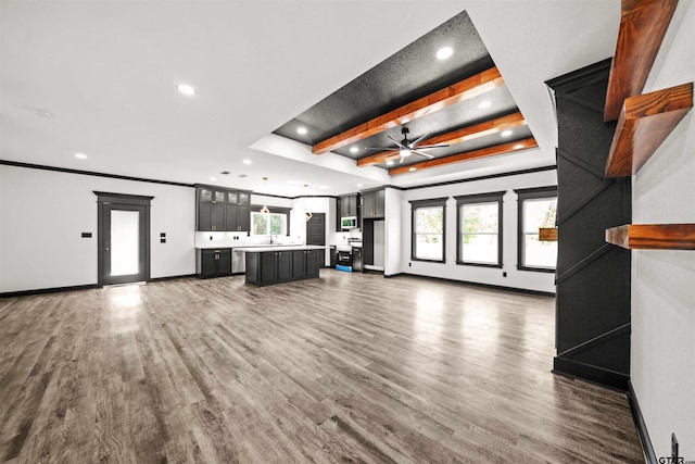 unfurnished living room featuring ceiling fan, plenty of natural light, and dark wood-type flooring