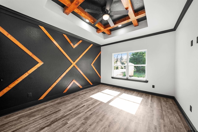 spare room featuring coffered ceiling, crown molding, hardwood / wood-style flooring, ceiling fan, and beamed ceiling