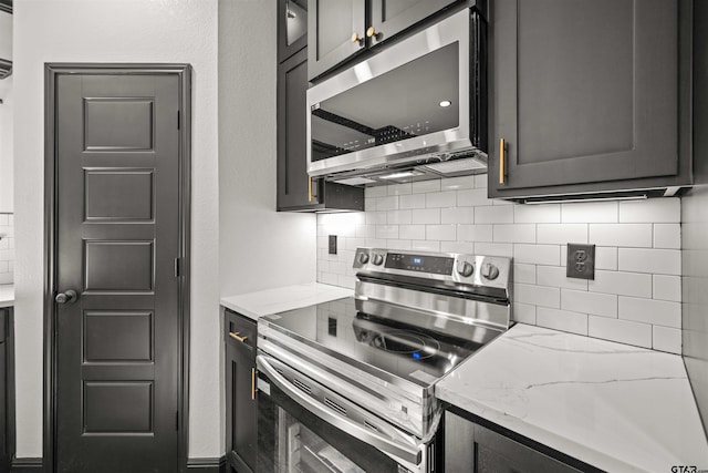 kitchen with decorative backsplash, light stone countertops, and appliances with stainless steel finishes