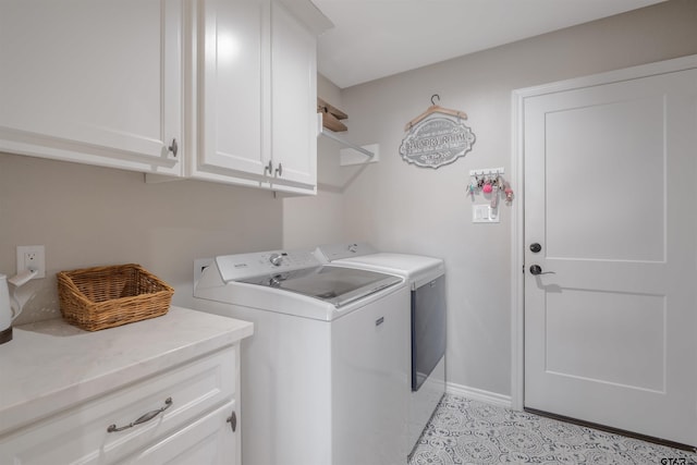 laundry area featuring washer and dryer, light tile patterned floors, and cabinets