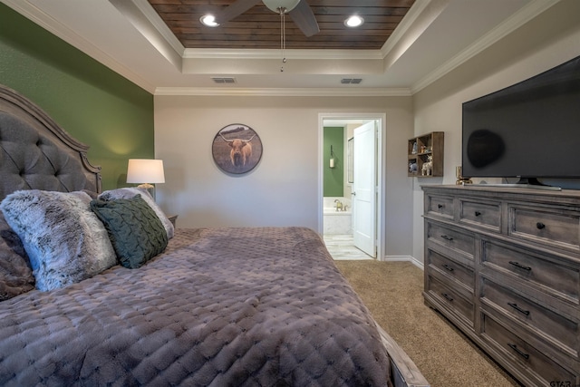 carpeted bedroom featuring ornamental molding, connected bathroom, and a tray ceiling