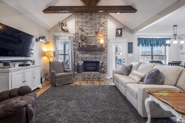 living room featuring lofted ceiling with beams, wood-type flooring, and a fireplace