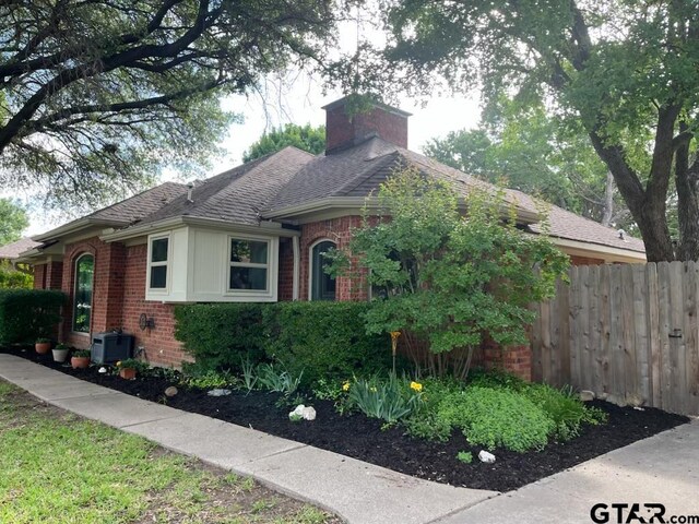 8720 Woodstream Dr, Frisco, TX 75034 - view of home's exterior featuring brick siding, fence, a chimney, roof with shingles, and cooling unit