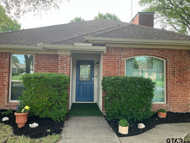 8720 Woodstream Dr, Frisco, TX 75034 - entrance to property featuring brick siding, a shingled roof, and a chimney