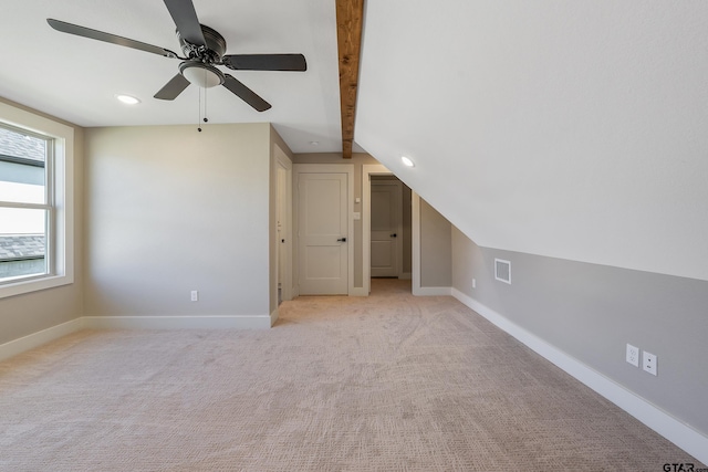 additional living space with ceiling fan, light carpet, and vaulted ceiling with beams