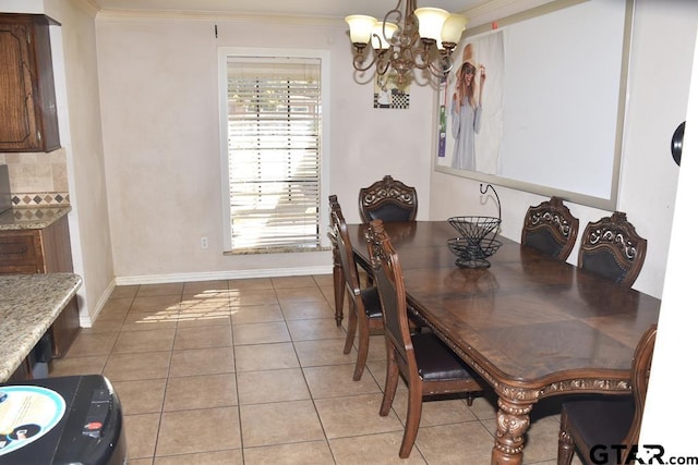 dining room with a notable chandelier, ornamental molding, and light tile patterned floors