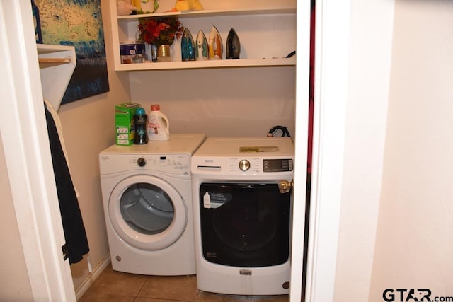 laundry room with washer and clothes dryer and light tile patterned floors