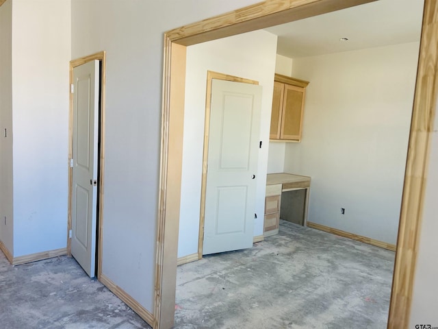 interior space with unfinished concrete flooring and baseboards