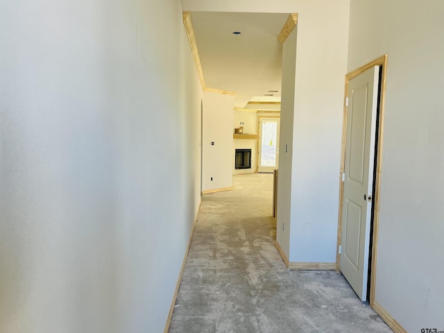 corridor with concrete floors and baseboards