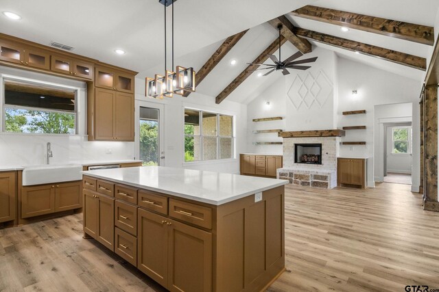 11905 Tara Ln, Lindale, TX 75771 - kitchen with a sink, plenty of natural light, a stone fireplace, beamed ceiling, and hanging light fixtures