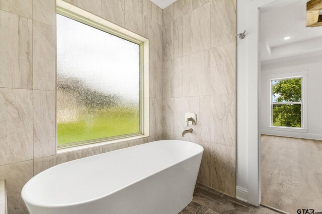 11905 Tara Ln, Lindale, TX 75771 - full bathroom featuring tile walls and a freestanding bath