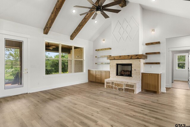 11905 Tara Ln, Lindale, TX 75771 - unfurnished living room featuring high vaulted ceiling, a ceiling fan, baseboards, a fireplace with raised hearth, and light wood-style floors