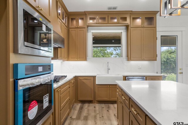 11905 Tara Ln, Lindale, TX 75771 - kitchen with stainless steel appliances, light countertops, light wood-type flooring, and healthy amount of natural light