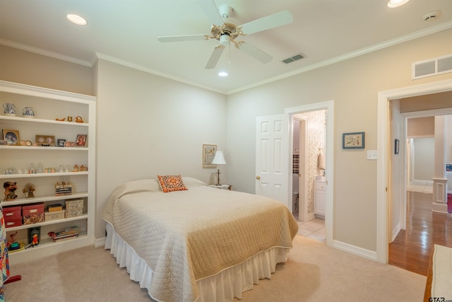 bedroom featuring light colored carpet, ensuite bath, ceiling fan, and crown molding