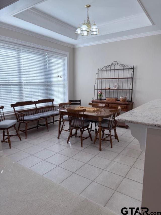 dining space with a chandelier, light tile patterned floors, a tray ceiling, and crown molding