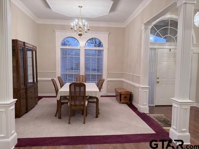 dining space featuring decorative columns, an inviting chandelier, and ornamental molding