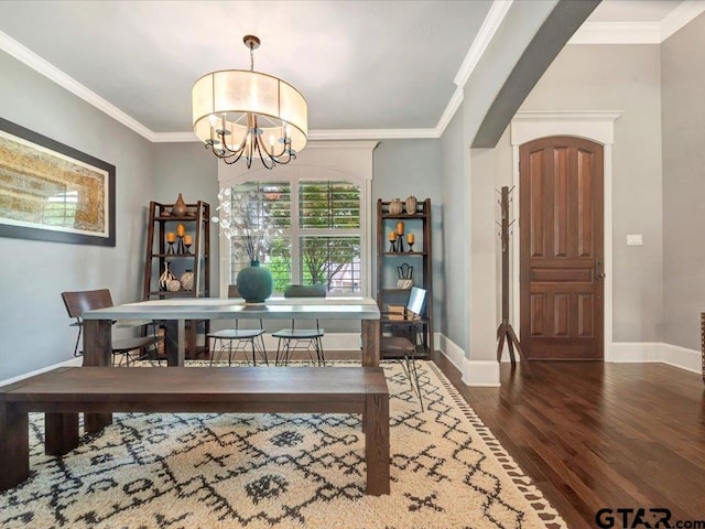 dining room featuring an inviting chandelier, baseboards, crown molding, and wood finished floors