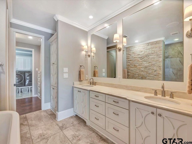 full bathroom with crown molding, washer / clothes dryer, and a sink