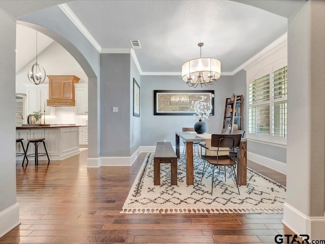 dining area featuring wood-type flooring, arched walkways, a notable chandelier, and visible vents