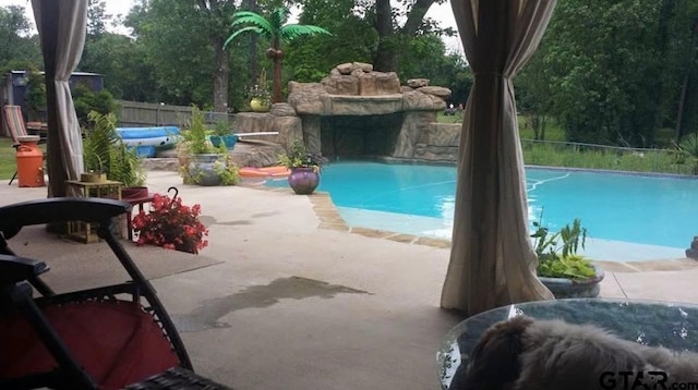 view of swimming pool featuring a patio area, fence, and a fenced in pool