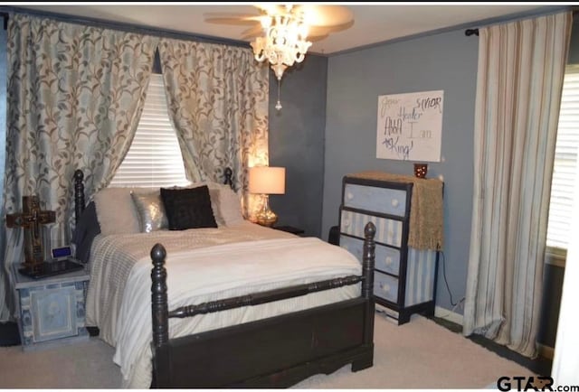 carpeted bedroom featuring ceiling fan and ornamental molding