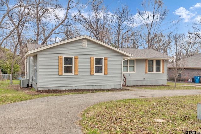 view of front of house with central AC unit and a front yard