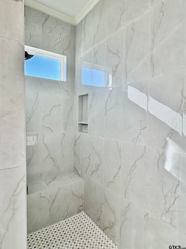 bathroom with a tile shower and crown molding