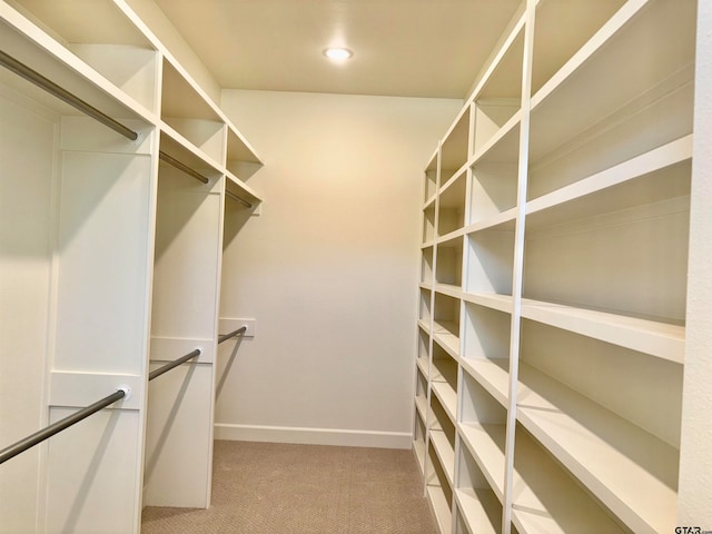 walk in closet featuring light carpet