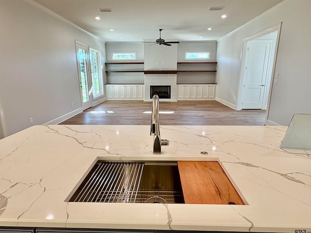 kitchen with tasteful backsplash, crown molding, sink, hardwood / wood-style floors, and ceiling fan