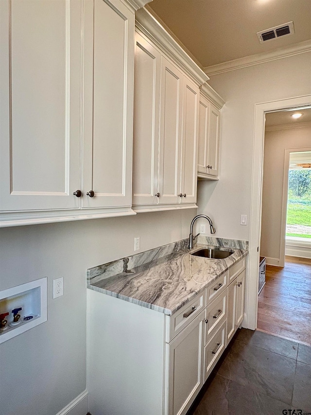 clothes washing area featuring dark hardwood / wood-style flooring, cabinets, sink, ornamental molding, and hookup for a washing machine