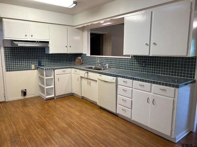 kitchen with tasteful backsplash, white cabinetry, white dishwasher, sink, and light hardwood / wood-style floors