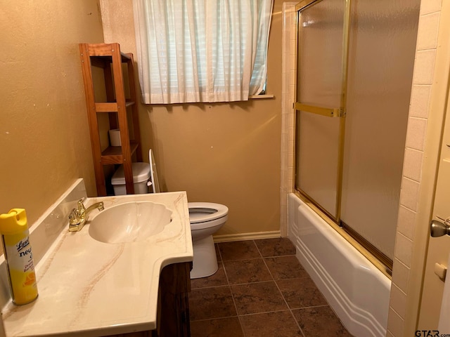 full bathroom featuring combined bath / shower with glass door, tile patterned floors, vanity, and toilet