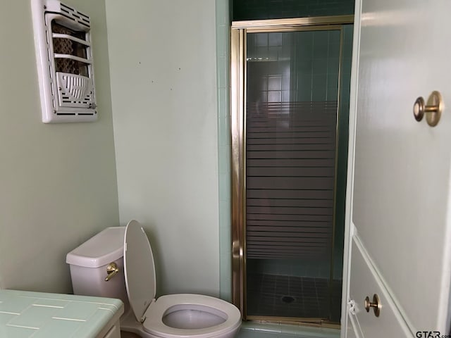 bathroom with toilet, vanity, and a shower with shower door