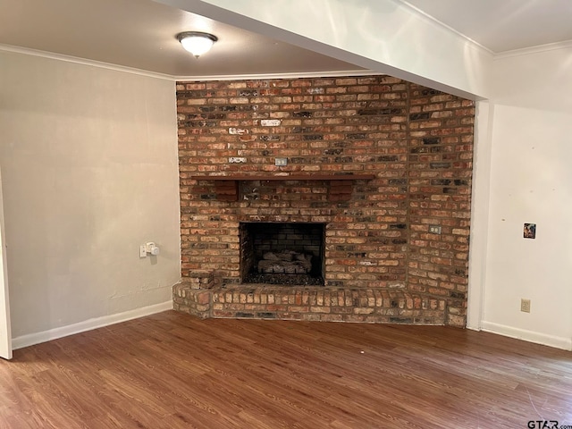 unfurnished living room featuring a brick fireplace, wood-type flooring, and ornamental molding