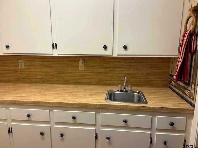 kitchen featuring white cabinetry, sink, and backsplash