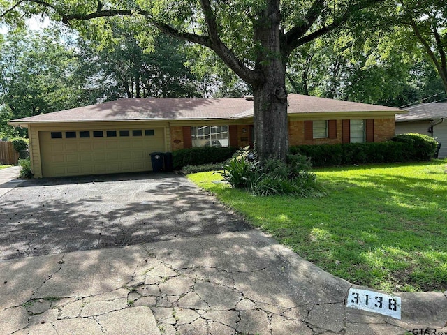 ranch-style house featuring a garage and a front lawn