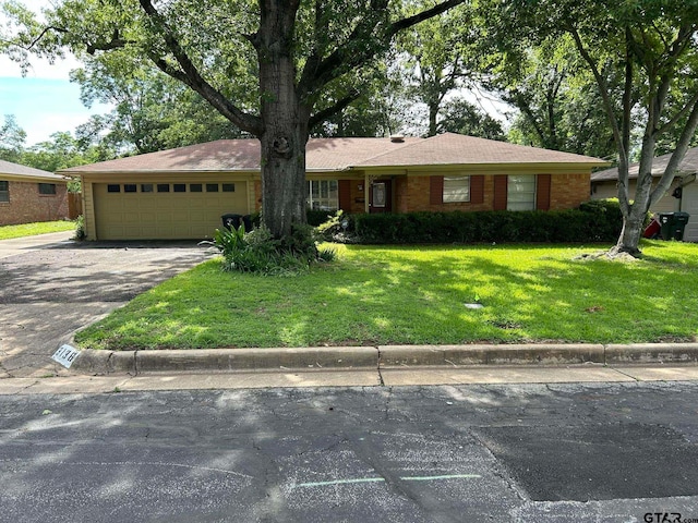 single story home with a garage and a front lawn