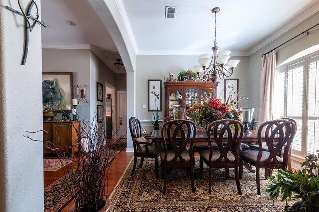 dining area featuring an inviting chandelier, light wood-type flooring, and ornamental molding