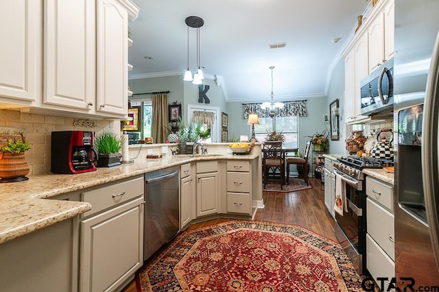 kitchen with stainless steel appliances, dark hardwood / wood-style flooring, kitchen peninsula, a chandelier, and pendant lighting