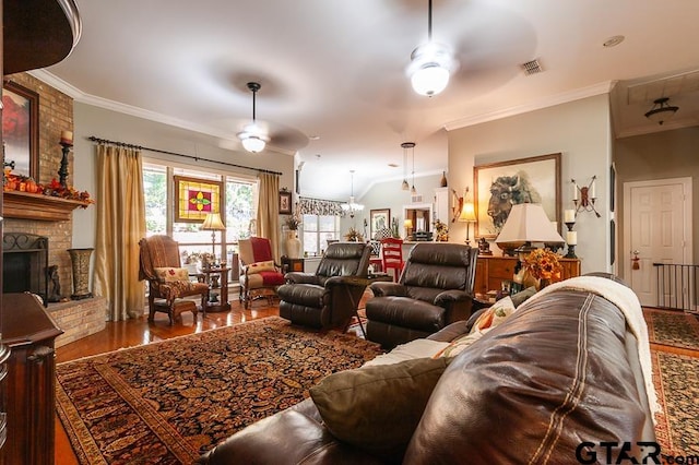 living room featuring a brick fireplace, wood-type flooring, ceiling fan, and crown molding