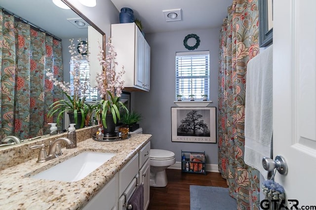 bathroom featuring wood-type flooring, vanity, and toilet