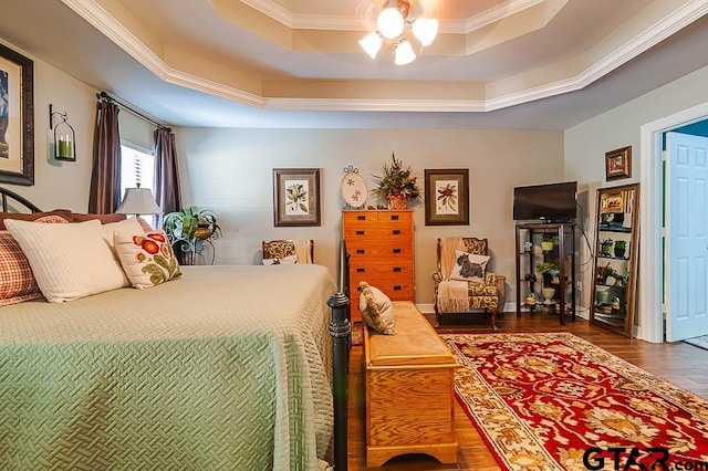 bedroom with crown molding, dark wood-type flooring, ceiling fan, and a raised ceiling