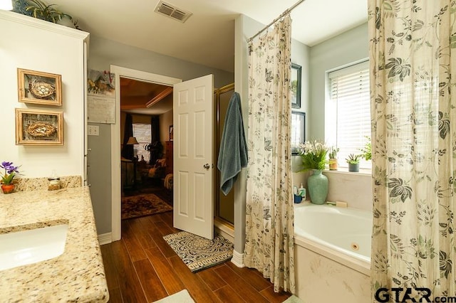 bathroom with independent shower and bath, vanity, and hardwood / wood-style floors