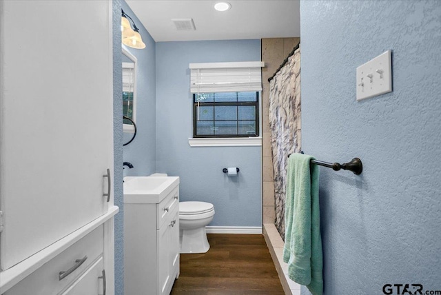 107 W Nutbush, Tyler, TX 75702 - full bath with vanity, wood finished floors, a shower with shower curtain, and a textured wall