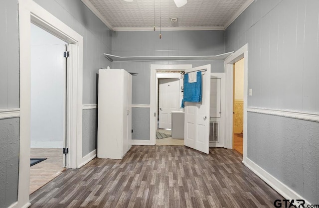 interior space with crown molding, dark hardwood / wood-style flooring, and wooden walls